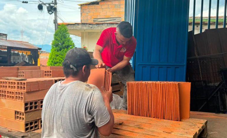 Trabajadores descargando materiales para reconstruir viviendas tras el terremoto